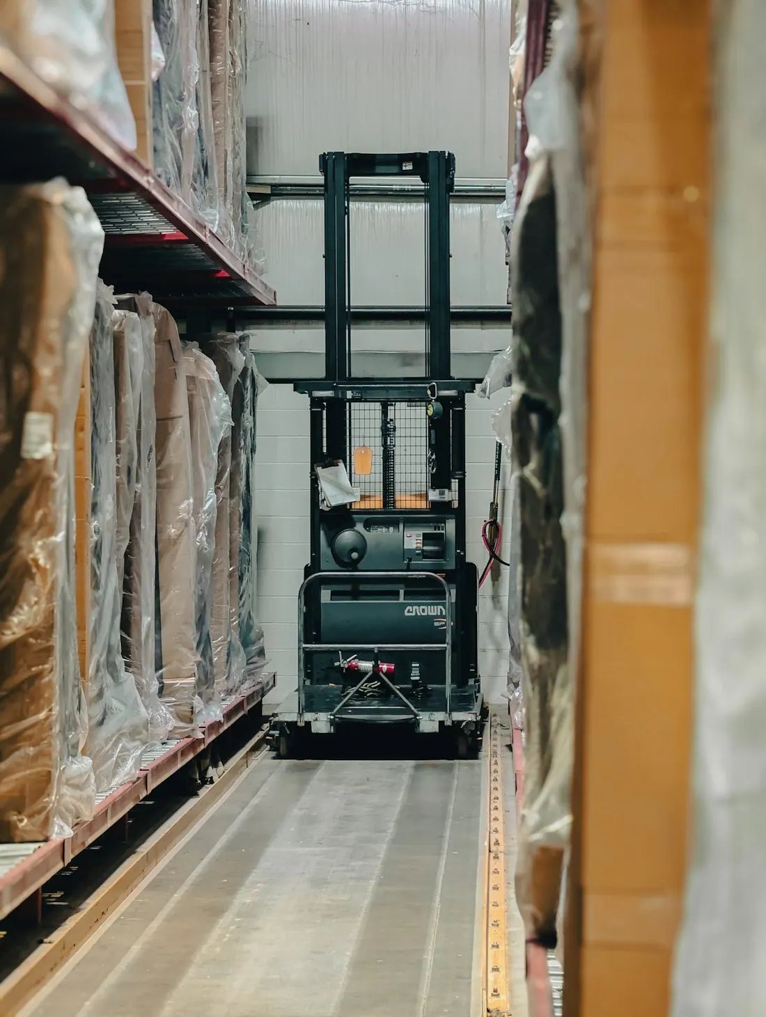 Forklift in an aisle between warehouse stock